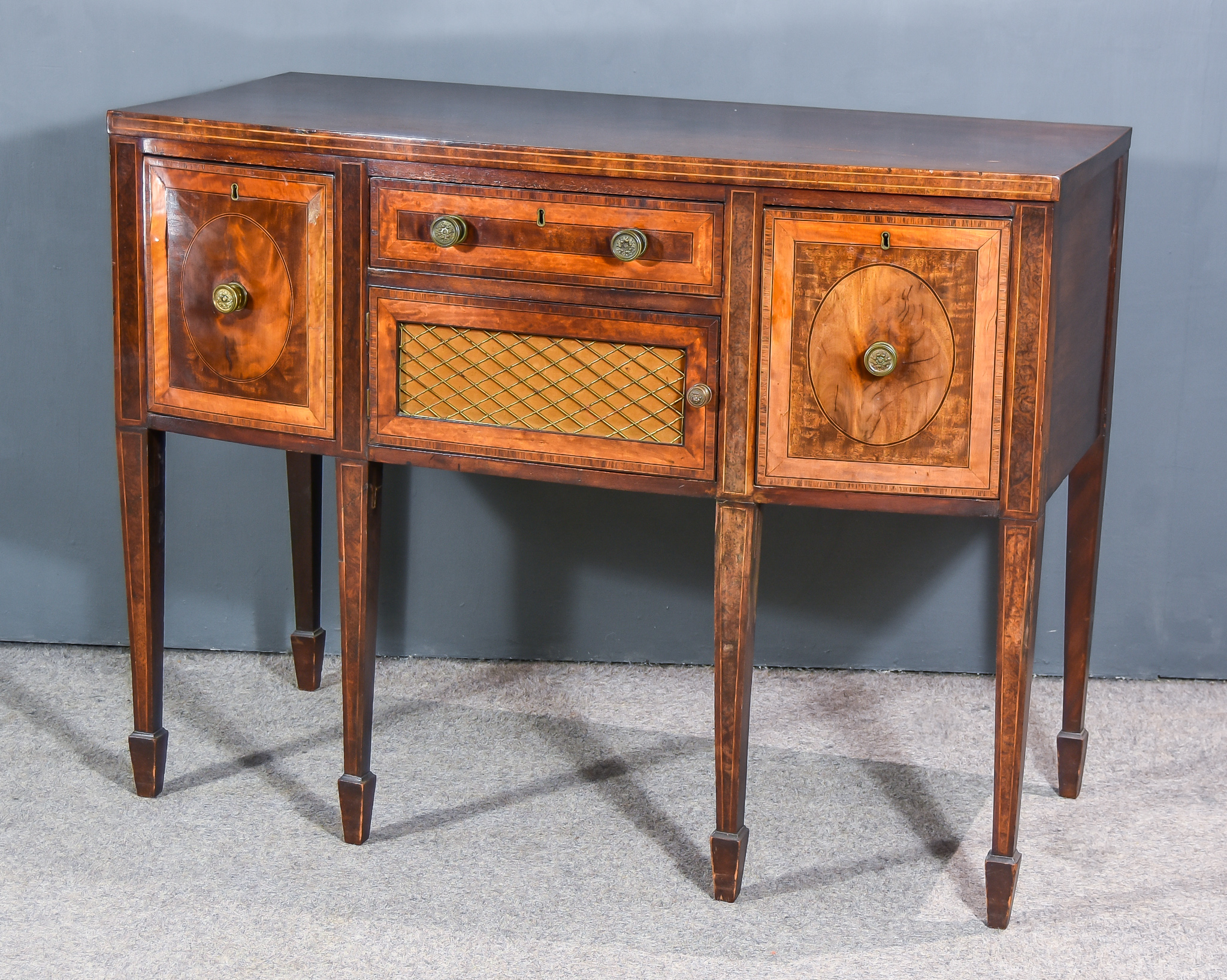 A George III Mahogany Bow Front Sideboard, with plain top, the front inlaid with stringings and