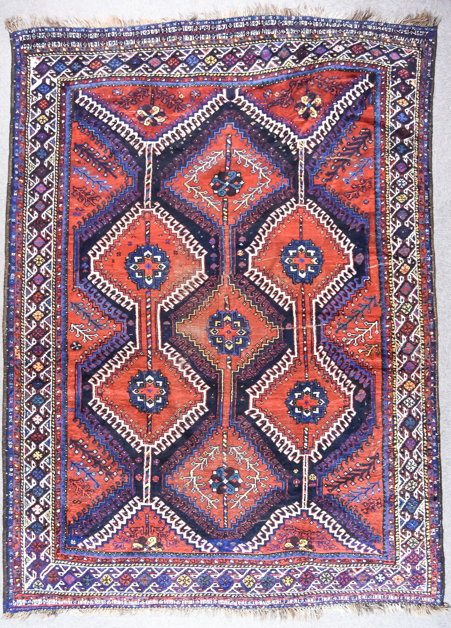 A 19th Century Qashqai Carpet, woven in colours of ivory, navy blue and wine, with seven stepped