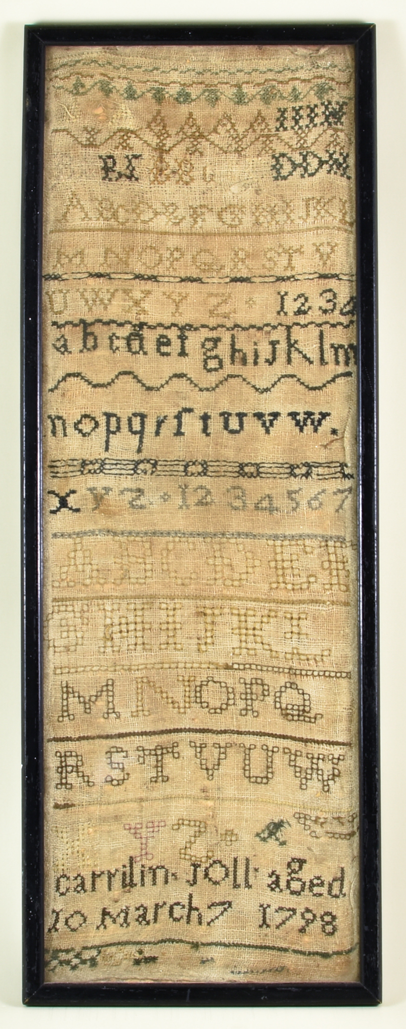 An English Sampler, worked in coloured silks by Carrilin Joll, dated 1798, with bands of alphabet