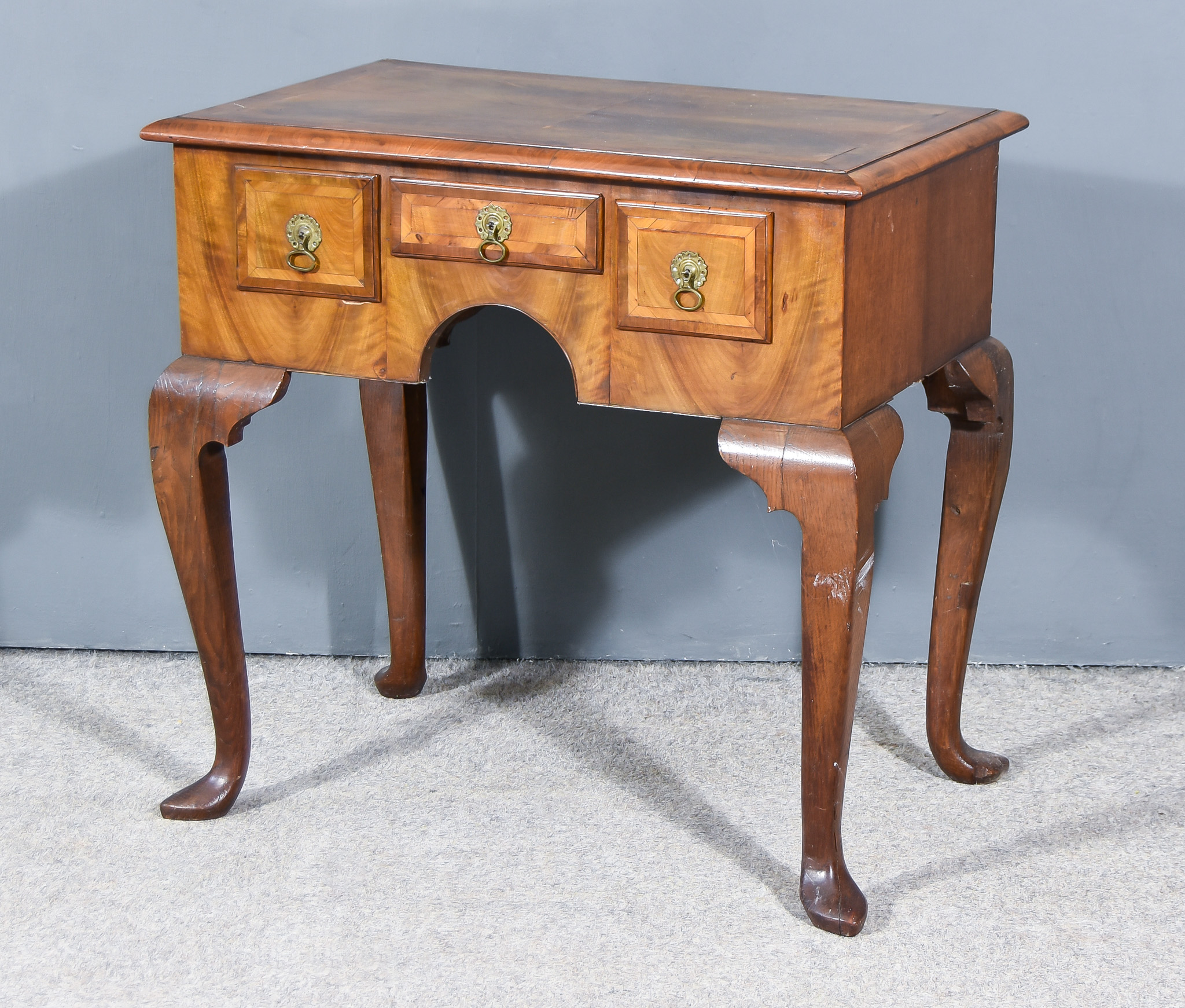 A Walnut Lowboy of Early 18th Century Design, with quarter veneer top and drawer fronts, inlaid with