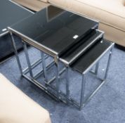 NEST OF THREE RECTANGULAR COFFEE TABLES WITH BLACK GLASS TOPS, with polished steel frames and