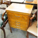 AN OAK SEWING CABINET, HAVING THREE DRAWERS BELOW A LIFT-UP LID