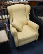 RECLINING WINGED FIRESIDE ARMCHAIR, covered in yellow check fabric, with automatically extending leg