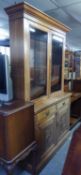 AN EARLY 20TH CENTURY CARVED WALNUT WOOD LIBRARY BOOKCASE, THE UPPER PORTION ENCLOSED BY TWO