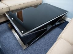 A LARGE OBLONG COFFEE TABLE, with black glass top on a  polished steel base with 'X' framed supports