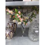 A GLASS URN SHAPED VASE WITH SILK APPLE BLOSSOM FLOWERS