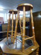 A PAIR OF HARDWOOD TALL KITCHEN STOOLS WITH CIRCULAR PANEL SEATS