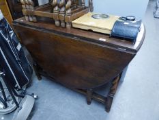 AN OAK GATELEG DINING TABLE RAISED ON BARLEY TWIST SUPPORTS