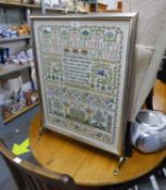 A BRASS CHEVAL GRATESCREEN WITH GLAZED AND NEEDLEWORK SAMPLER PANEL WORKED BY JOYCE KENNEDY