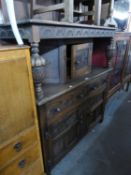 AN OAK COURT CUPBOARD, WITH CARVED DECORATION, ALSO HAVING PINEAPPLE CARVED UPRIGHTS TO UPPER