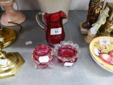 VICTORIAN CRANBERRY GLASS CREAM JUG AND TWO CRANBERRY GLASS SALT RECEIVERS