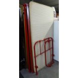 AN ANTIQUE HEAVY RED METAL HOSPITAL SINGLE BED WITH BASE