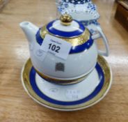 A MODERN 'HOUSE OF LORDS' TEAPOT AND CUP AND SAUCER, BLUE AND GOLD BANDED, EACH GILT WITH 'PALACE OF