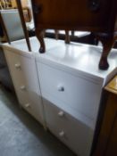 A PAIR OF WHITE MELAMINE BEDSIDE CHESTS OF THREE DEEP DRAWERS AND A CHROMED TUBULAR METAL  TEA