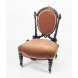VICTORIAN AESTHETICS MOVEMENT EBONISED AND PARCEL GILT NURSING CHAIR WITH GILT METAL MOUNTS, the