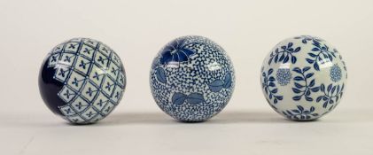 THREE EARLY 20th CENTURY BLUE AND WHITE CERAMIC SPHERICAL BALLS/STRESS BALLS, varying patterns,