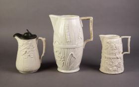 COPELAND OR ATTRIBUTED TO, THREE NINETEENTH CENTURY RUSTIC MOULDED AND WHITE GLAZED POTTERY JUGS,