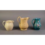 MINTONS OR ATTRIBUTED TO, THREE NINETEENTH CENTURY RELIEF MOULDED POTTERY JUGS, one buff glazed