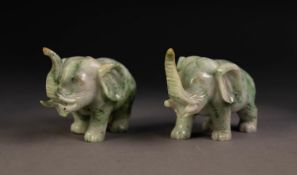 PAIR OF CHINESE CARVED SPECKLED GREY/GREEN MODELS OF ELEPHANTS, with trunks raised, 2 1/4in (5.75cm)