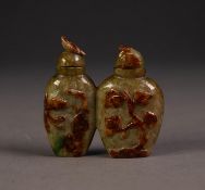 TWO CHINESE GREEN AND BROWN JADE CONJOINED SNUFF BOTTLES AND STOPPERS, ovular, the fronts carved