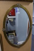 AN INTER-WAR YEARS PLANISHED BRASS FRAMED OVAL BEVELLED WALL MIRROR, 33" (84cm) high