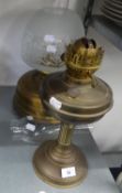 A LARGE BRASS OIL LAMP WITH GLASS SHADE AND FUNNEL AND A BRASS OIL TABLE LAMP WITH GLASS FUNNEL