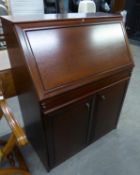 A REPRODUCTION MAHOGANY BUREAU WITH FALL-FRONT OVER TWO CUPBOARDS (107cm HIGH X 83cm WIDE x 46cm