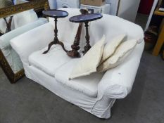 A TWO SEATER SETTEE, COVERED IN WHITE LINING AND THE PLAIN WHITE COTTON LOOSE COVERS