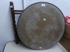 MIDDLE EASTERN ENGRAVED BRASS COFFEE TABLE WITH CIRCULAR TOP AND FOLDING WOOD BASE, lacking one