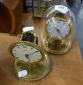 TWO KUNDO SMALL ANNIVERSARY CLOCKS ON CIRCULAR BASES, (ONE ONLY WITH GLASS DOME SHADE)