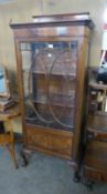 A GOOD QUALITY EARLY 20TH CENTURY FIGURED MAHOGANY DISPLAY CABINET WITH LEDGE BACK, THE SINGLE