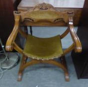 A CARVED MAHOGANY 'X' FRAMED OPEN ARMCHAIR, WITH PADDED SHOULDER BOARD AND SADDLE SEAT COVERED IN