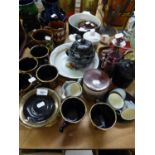 TELLA, GREEK BLACK AND GOLD POTTERY PART TEA SERVICE; A BROWN AND PRINTED POTTERY TEAPOT, ON STAND