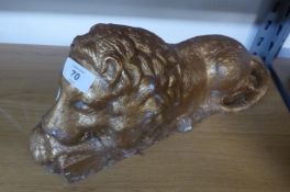 A GILT METAL RECLINING LION PATTERN DOORSTOP