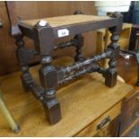 JACOBEAN STYLE OAK OBLONG STOOL, WITH CANE PANEL SEAT, ON TURNED AND SQUARE LEGS WITH TWO TIERS OF