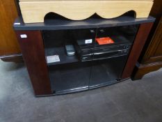 A BLACK FINISH CORNER TELEVISION STAND, THE CUPBOARD BASE ENCLOSED BY TWO PLATE GLASS FOLDING DOORS,