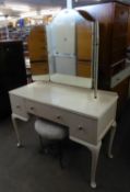 A WHITE FINISH KNEEHOLE DRESSING TABLE WITH FRAMELESS TRIPLE DRESSING MIRROR AND A BLACK METAL