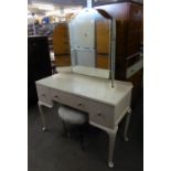 A WHITE FINISH KNEEHOLE DRESSING TABLE WITH FRAMELESS TRIPLE DRESSING MIRROR AND A BLACK METAL