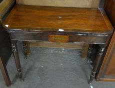 A REGENCY FLAMED MAHOGANY TEA TABLE, HAVING BRASS INLAY, RAISED ON TURNED SUPPORTS (A.F.)