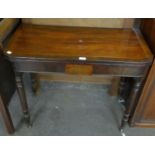 A REGENCY FLAMED MAHOGANY TEA TABLE, HAVING BRASS INLAY, RAISED ON TURNED SUPPORTS (A.F.)