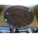 AN INDIAN EMBOSSED COPPER CIRCULAR PLAQUE