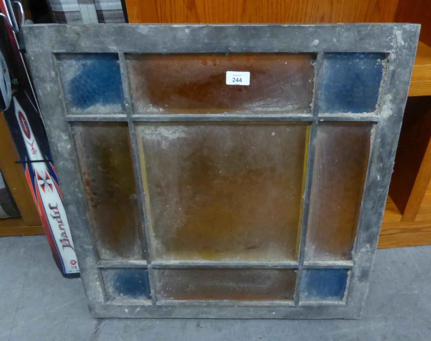 A SQUARE WOODEN FRAMED STAINED GLASS WINDOW