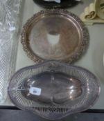 AN ELECTROPLATE PIERCED OVAL PEDESTAL CAKE DISH AND A SILVER ON COPPER CHASED CIRCULAR SALVER WITH