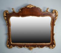 CARVED MAHOGANY AND PARCEL GILT WALL MIRROR, of shaped oblong form with