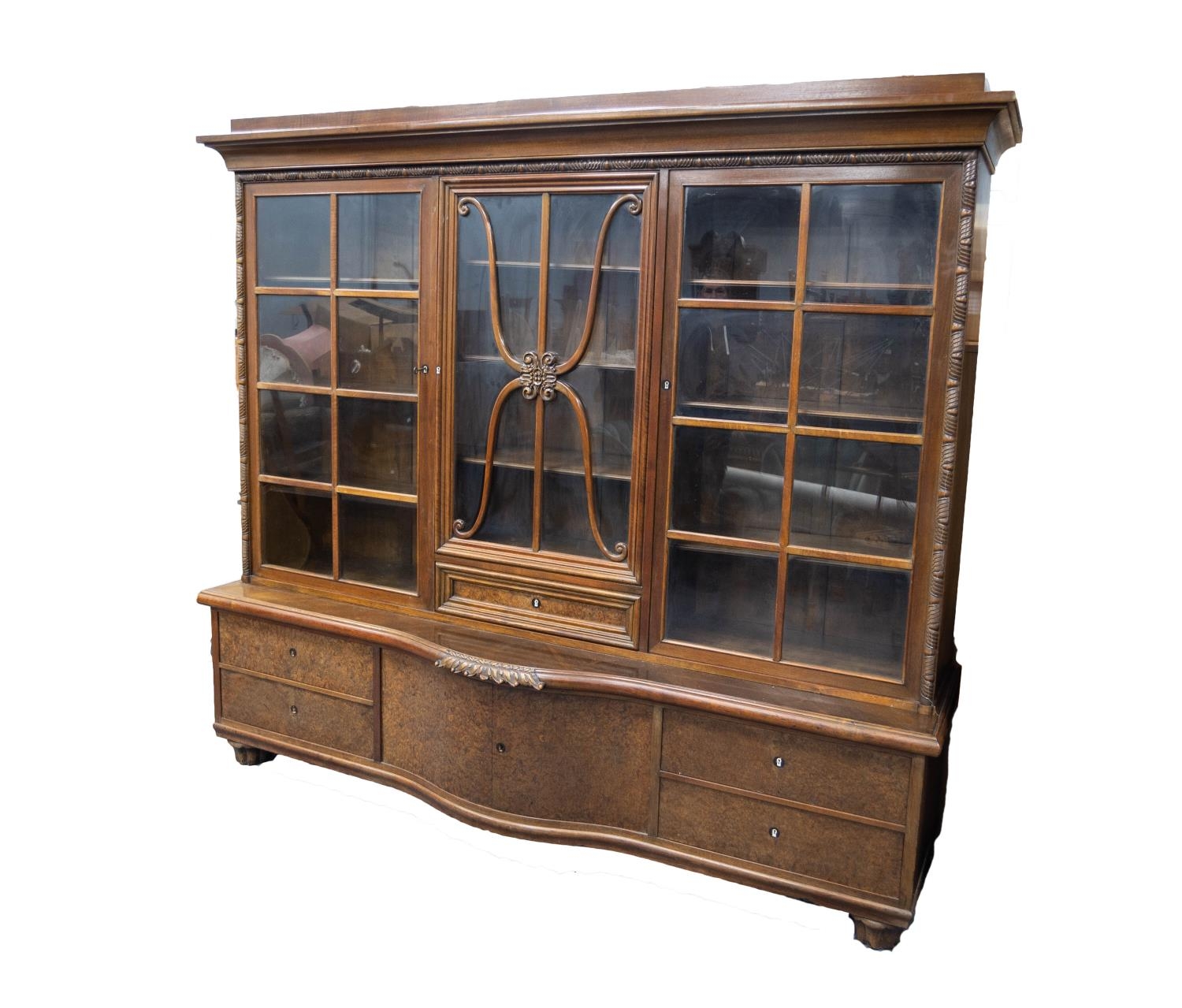 TWENTIETH CENTURY CONTINENTAL CARVED AND FIGURED WALNUT LIBRARY BOOKCASE, the moulded cornice