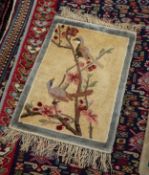 CHINESE PART SILK SMALL PICTORIAL RUG depicting two small garden birds on a flowering bough, pale