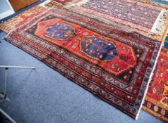 ZANJAN, PERSIAN HANDMADE WOOL RUG, with two blue pole medallions in blue on a wine red field