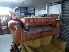 A THOMAS LLOYD BROWN LEATHER UPHOLSTERED SOFA OF GENEROUS PROPORTIONS, BRASS STUDDED, WITH TWO LOOSE