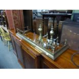 AN EARLY TWENTIETH CENTURY BRASS FENDER AND A PAIR OF BRASS ANDIRONS (3)