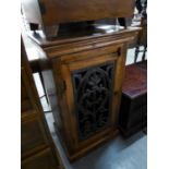 A MODERN MIDDLE EASTERN SMALL CUPBOARD, THE DOOR WITH OPEN WORK CAST PANEL, PLINTH BASE